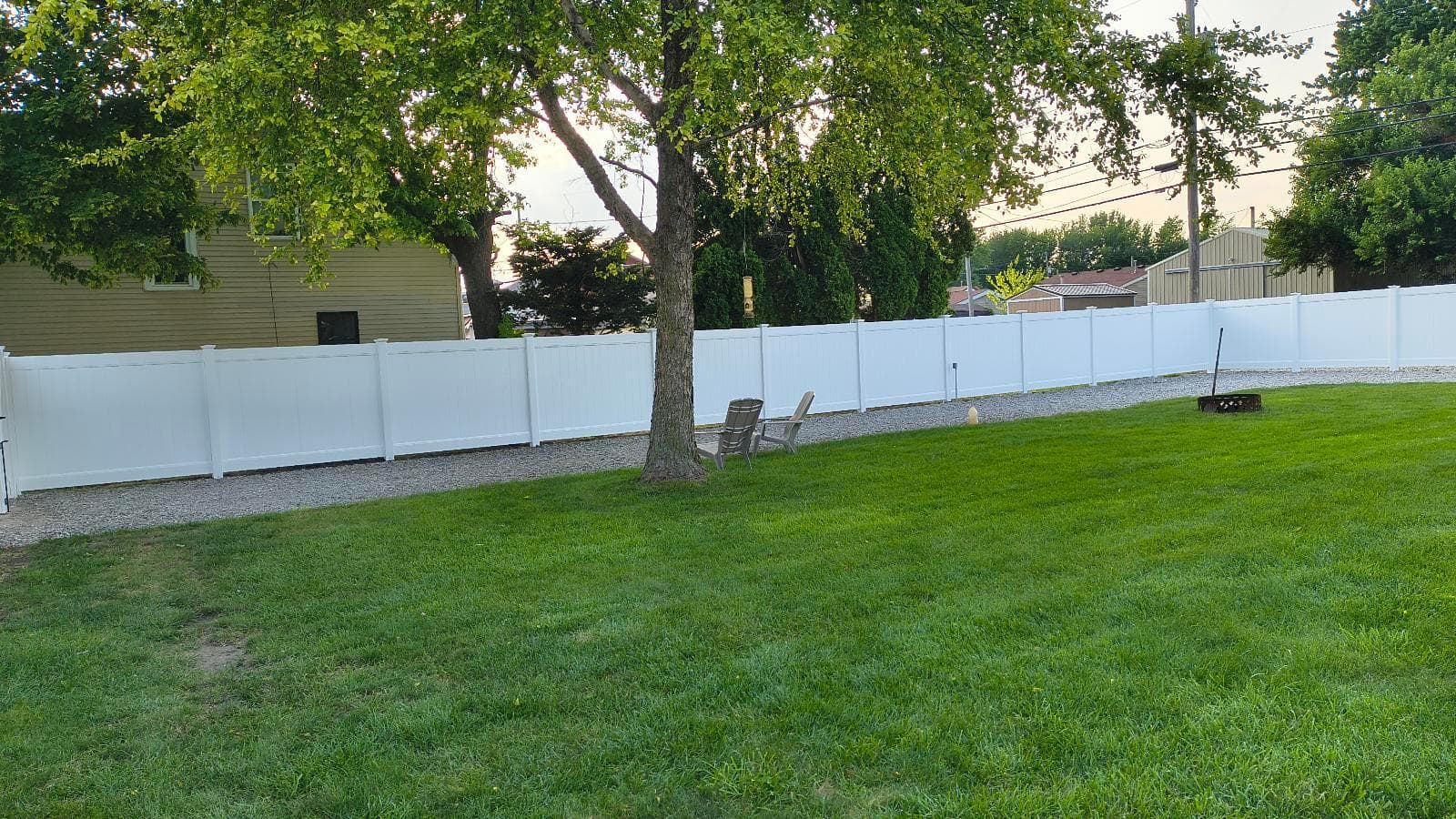 White vinyl privacy fence enclosing a tree-lined backyard at Ideal Fence's Kokomo installation.